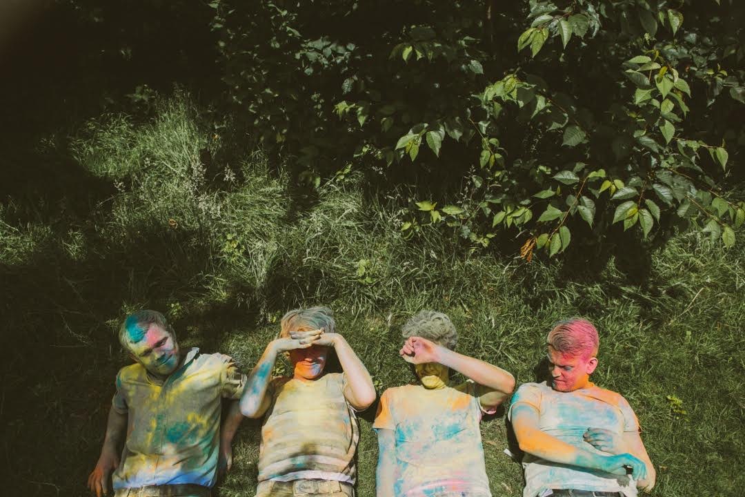 The Crookes band lying on grass covered in paint