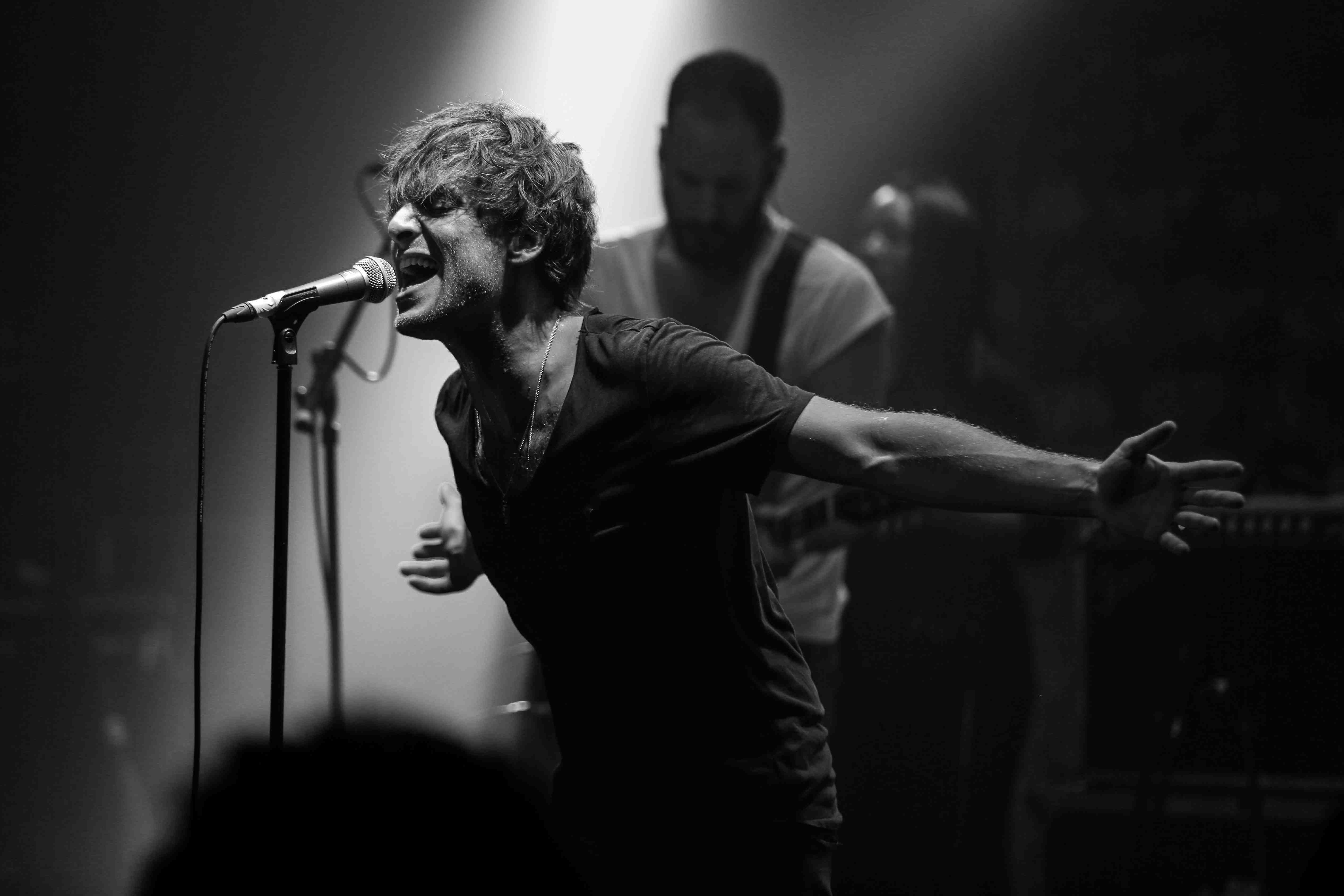 Black and white image of Paolo Nutini singing on stage