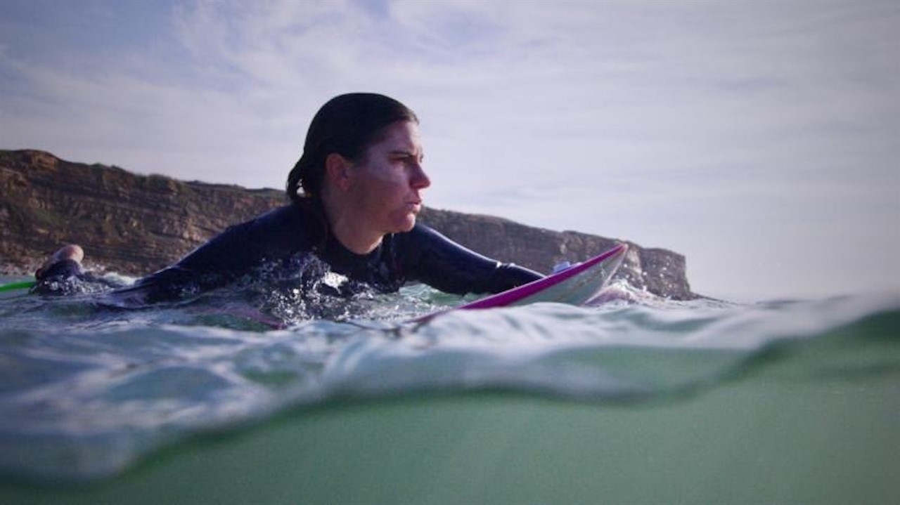 Joana Andrade paddling on a surfboard