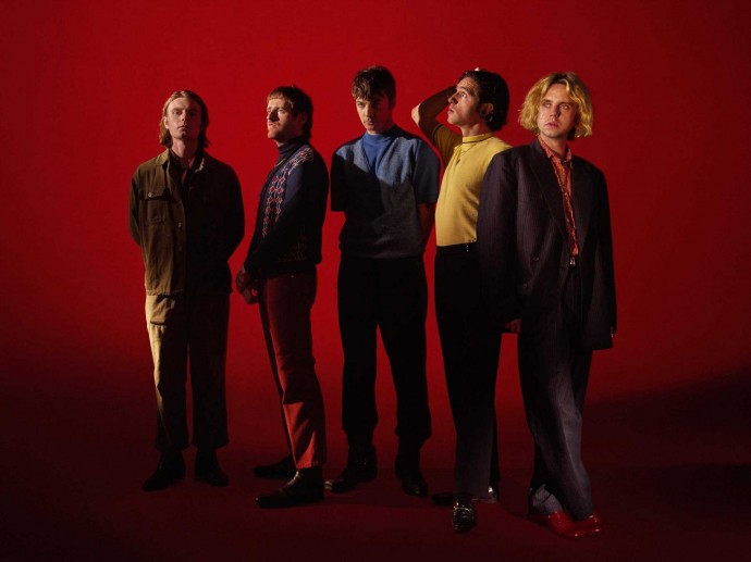 The five members of the band Fontaines D.C. with a red background